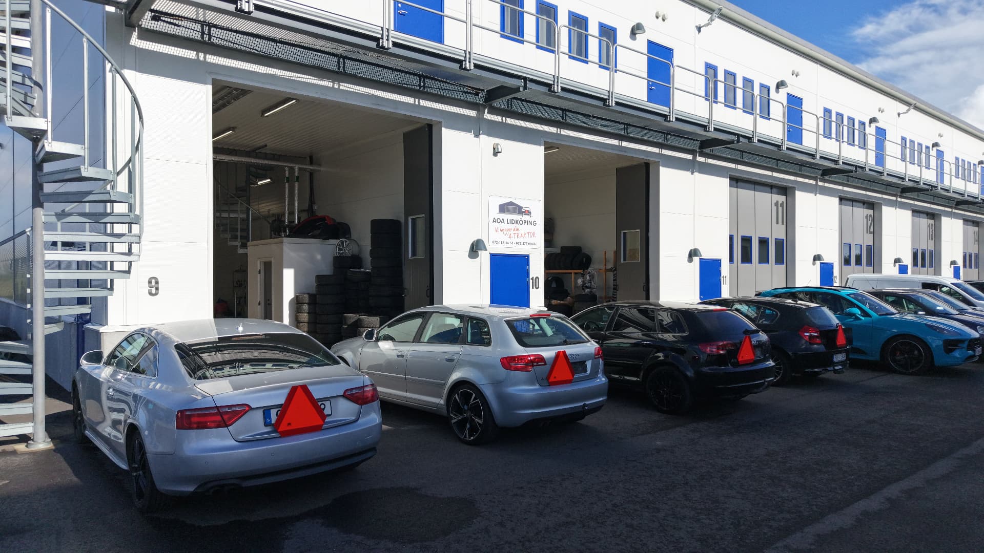 Vit cabriolet framför en röd lada
